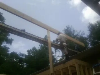 Carpenter setting a ridge beam over a new addition frame — Ice Dam Removal by Roofing Brothers in Speedwell