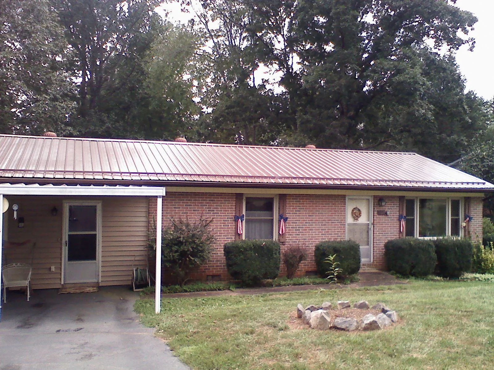 Bronze metal roof and carport on a brick ranch home — Roof Repair work by our crew in Speedwell